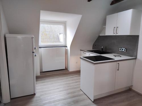 a kitchen with white cabinets and a white refrigerator at Kleine Perle bei Hamburg in Reinbek