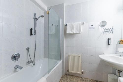 a bathroom with a shower and a sink at Hotel Tia Monte Nauders in Nauders