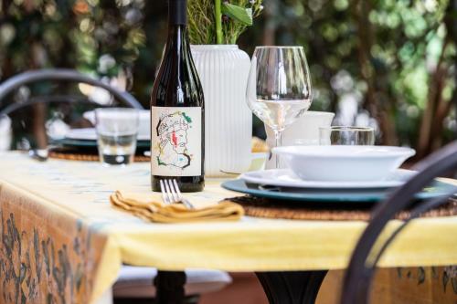a table with a bottle of wine and a glass at Casetta di Butia, Glicine Apartment in Borgo a Mozzano