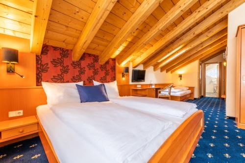 sypialnia z dużym białym łóżkiem w pokoju w obiekcie Hotel Tia Monte Nauders w mieście Nauders