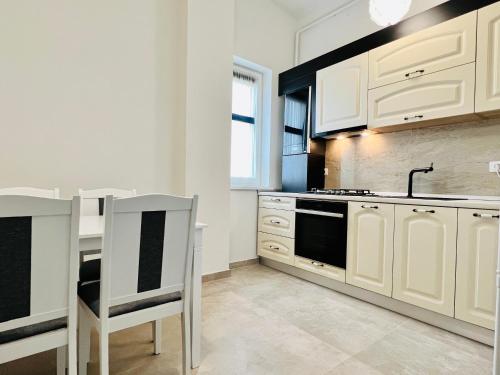 a kitchen with white cabinets and a sink and a stove at Altheda Living Topaz 29C-14 in Sfîntu Ilie