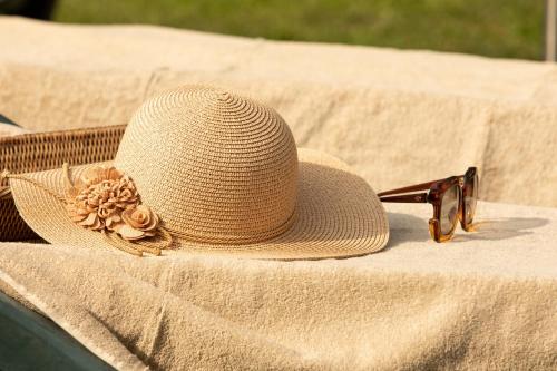 a straw hat and sunglasses sitting on a table at Casetta di Butia, Gelsomino Apartment in Borgo a Mozzano