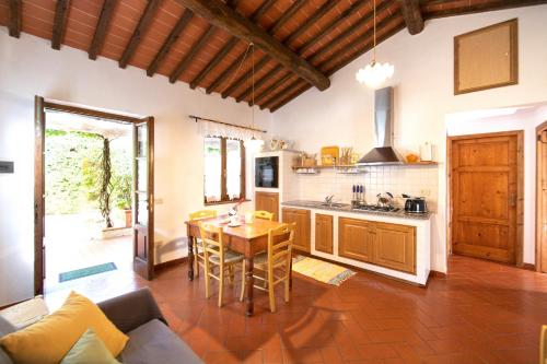 a kitchen with a wooden table and a kitchen with a couch at Casetta di Butia, Gelsomino Apartment in Borgo a Mozzano