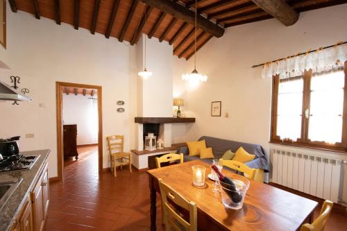 a kitchen and living room with a table and a couch at Casetta di Butia, Gelsomino Apartment in Borgo a Mozzano
