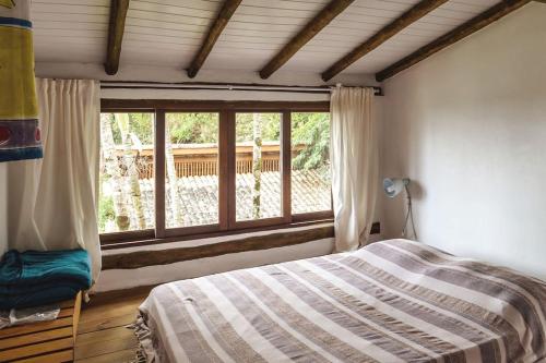 1 dormitorio con cama y ventana grande en llhabela incrível vista e piscina, en Ilhabela