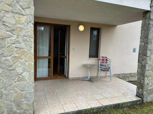 une terrasse avec une table et une chaise en face d'une maison dans l'établissement Bernadett Villa Apartman 3, à Bük