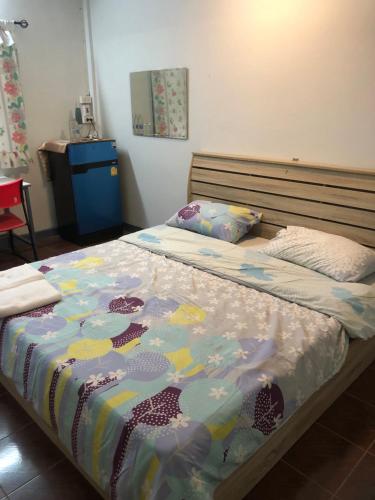 1 dormitorio con 1 cama con un edredón colorido en Baansuan bbq and Resort number 5, en Khon Kaen