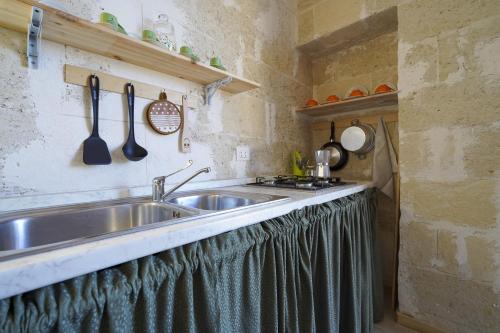 cocina con fregadero y encimera con utensilios en La Casa di Marta, en Faccia di Trippa