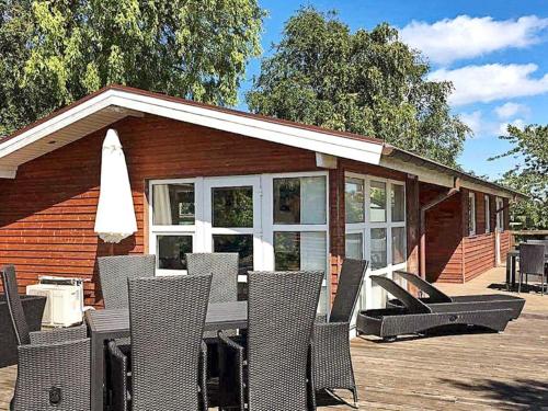 une terrasse avec des chaises, une table et une maison dans l'établissement 10 person holiday home in Juelsminde, à Juelsminde