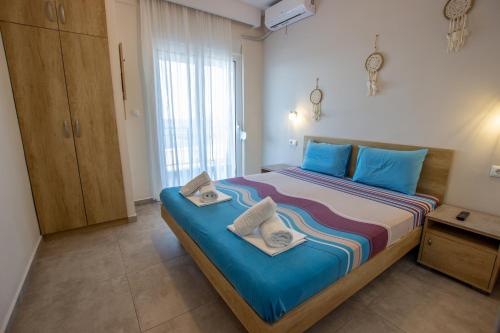 a bedroom with a large bed with towels on it at House Kohili in Nea Vrasna