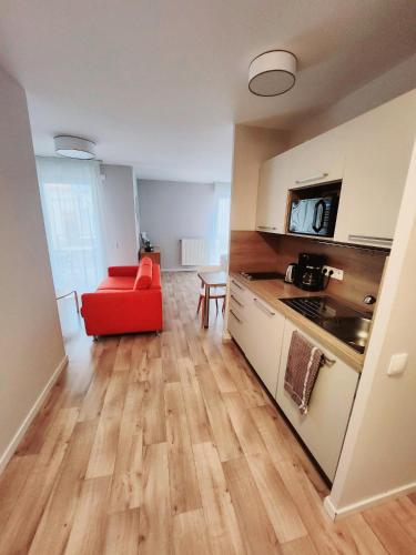 a kitchen with a red chair in a room at DOMITYS - Le Fil de Soie in Calais