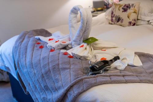 a bed with a bottle of wine on it at Holly Lodge Guest House with FREE off site health club in Windermere