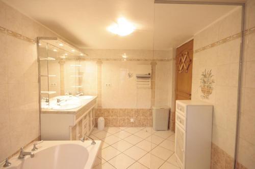 a bathroom with a tub and a sink and a mirror at Gîte aux 2 vignes - Grande maison idéale en famille ou entre amis - Animaux acceptés in Kientzheim