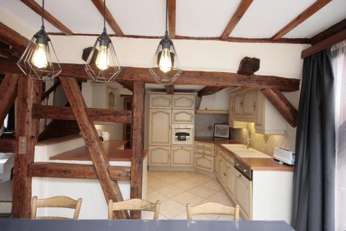 a kitchen with wooden beams and a table and chairs at Gîte aux 2 vignes - Grande maison idéale en famille ou entre amis - Animaux acceptés in Kientzheim