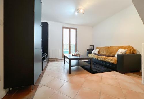 un salon avec un canapé et une table dans l'établissement Le Calmette-Maison avec bel espace de vie en duplex- Climatisation- WIFI- terrain de pétanque-, à Saint-Clément