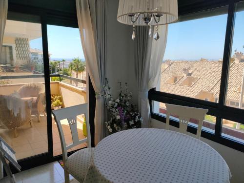 Zimmer mit einem Tisch und Stühlen sowie einem Balkon in der Unterkunft Casas Holiday - Golf Campoamor in Orihuela