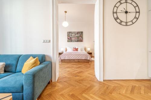 a living room with a blue couch and a bedroom at Stylish luxury flat in Old Town in Staré Mesto