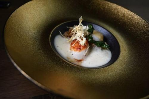 a bowl of food on a plate on a table at Logis Hotel Restaurant Au Boeuf Rouge in Niederschaeffolsheim