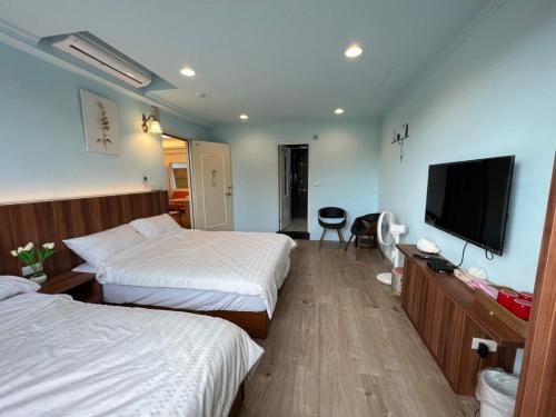 三芝區的住宿－旅途中海邊民宿，酒店客房设有两张床和一台平面电视。