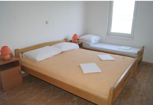 a bedroom with two beds and a window at Vila Slatine - Beach Apartments in Slatine