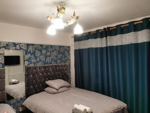 1 dormitorio con cama y cortina azul en 116 maison dieu Road room B in Dover, en Dover