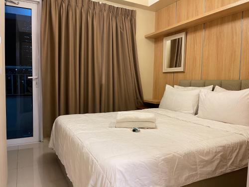 a bedroom with a large white bed with a window at Netflix- Destina Stays at Jazz Residences Makati, MetroManila in Manila