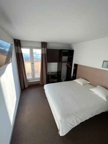 a bedroom with a large white bed and a window at Adonis Arc Hotel Aix in Aix-en-Provence