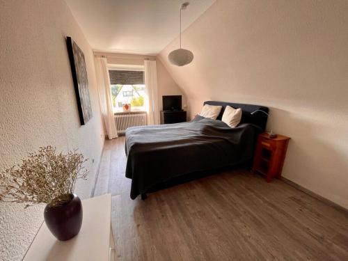 een slaapkamer met een bed, een tafel en een raam bij Dein idyllisches Zuhause auf Zeit in Norderstedt in Norderstedt