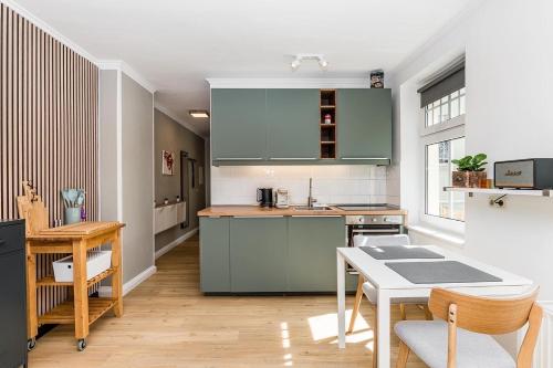 una cocina con armarios verdes y una mesa en stadtRaum-berlin apartments, en Berlín