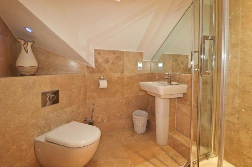 a bathroom with a toilet and a sink at STYLISH, BEACHSIDE apartment, sea views in St Merryn