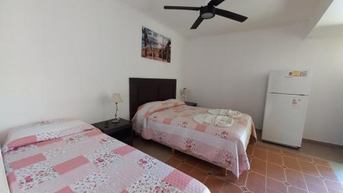 1 dormitorio con 2 camas y nevera en Complejo Playa Norte en Mar de Ajó