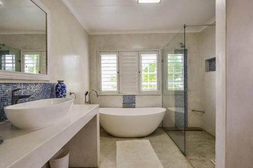 a bathroom with two sinks and a tub and a shower at Magnificent beach house with stunning ocean views! in Zinkwazi Beach