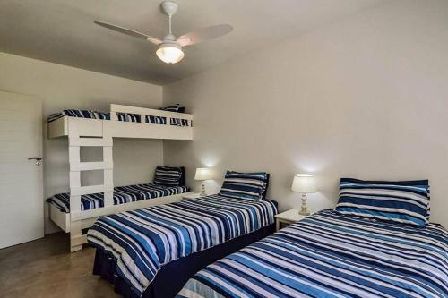 a bedroom with two beds and a ceiling fan at Magnificent beach house with stunning ocean views! in Zinkwazi Beach