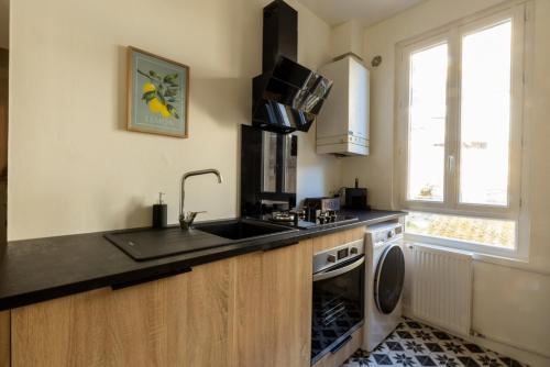 une cuisine avec un évier et un lave-vaisselle dans l'établissement La Canopée Vannetaise - T3 hypercentre de Vannes, à Vannes