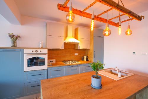 a kitchen with blue cabinets and a wooden counter top at House DIKA- sauna & jacuzzi in Otočac