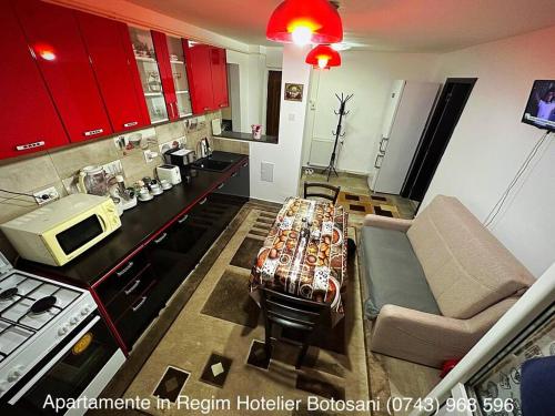 a kitchen with a table and a couch in a room at Apartament cu 2 camere/Curte privata/La parter/Lux oferim factura in Botoşani