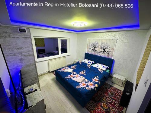 una camera da letto con un letto blu e cuscini sopra di Apartament cu 2 camere/Curte privata/La parter/Lux oferim factura a Botoşani
