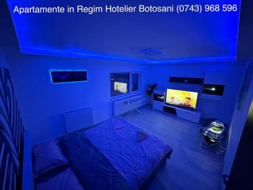 a blue room with a bed and a tv at Apartament cu 2 camere/Curte privata/La parter/Lux oferim factura in Botoşani