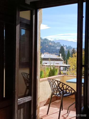 a door to a patio with a table and a bench at Nasrid Generalife - Carmen con patio ajardinado y vistas panorámicas in Granada