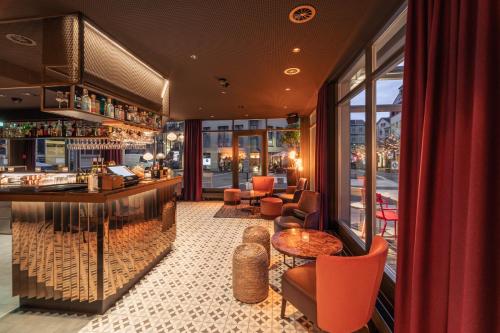 a restaurant with a bar with a view of the street at The HEY HOTEL in Interlaken
