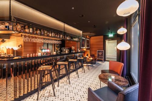 a restaurant with a bar with chairs and tables at The HEY HOTEL in Interlaken