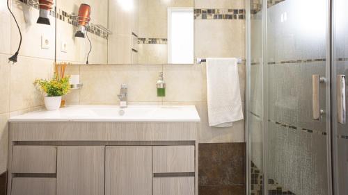 La salle de bains est pourvue d'un lavabo et d'une douche. dans l'établissement Casa da Praia - São Rafael - BY BEDZY, à Albufeira