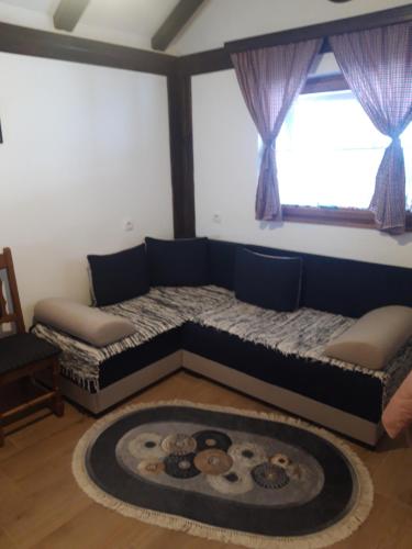 1 dormitorio con 2 camas y una alfombra grande en Kolibica en Mitrovac
