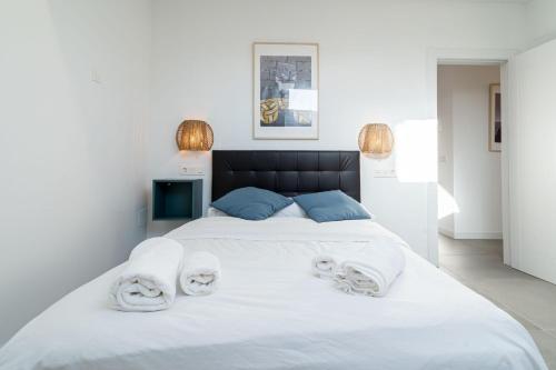 a bedroom with a large white bed with towels on it at Edificio Santiago by Plaza Mayor Apartamentos in Valladolid