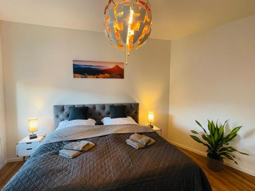 1 dormitorio con 1 cama con 2 almohadas y lámpara de araña en schönes Apartment - Netflix-Nespresso en Duisburg
