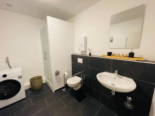 a bathroom with a sink and a toilet and a mirror at schönes Apartment - Netflix-Nespresso in Duisburg