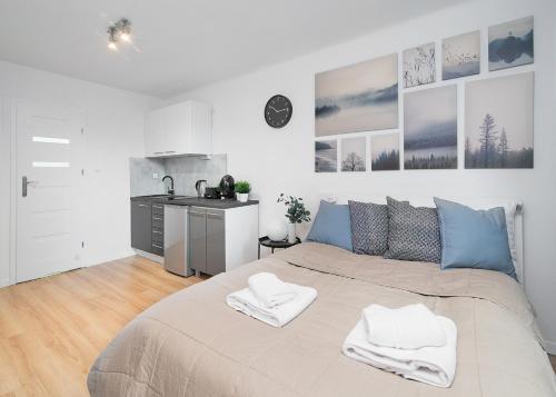 a bedroom with a large bed with two white towels at Central Apartments Grzybowska in Warsaw