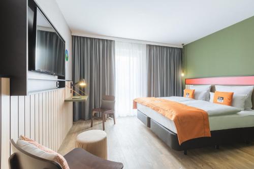 ein Hotelzimmer mit einem Bett und einem TV in der Unterkunft the niu Amity in Potsdam