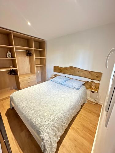 1 dormitorio con 1 cama grande y estanterías de madera en Superbe appartement avec piscine, en Carqueiranne