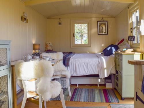 um quarto com uma cama, uma mesa e cadeiras em Molly The Shepherds Hut em Bampton